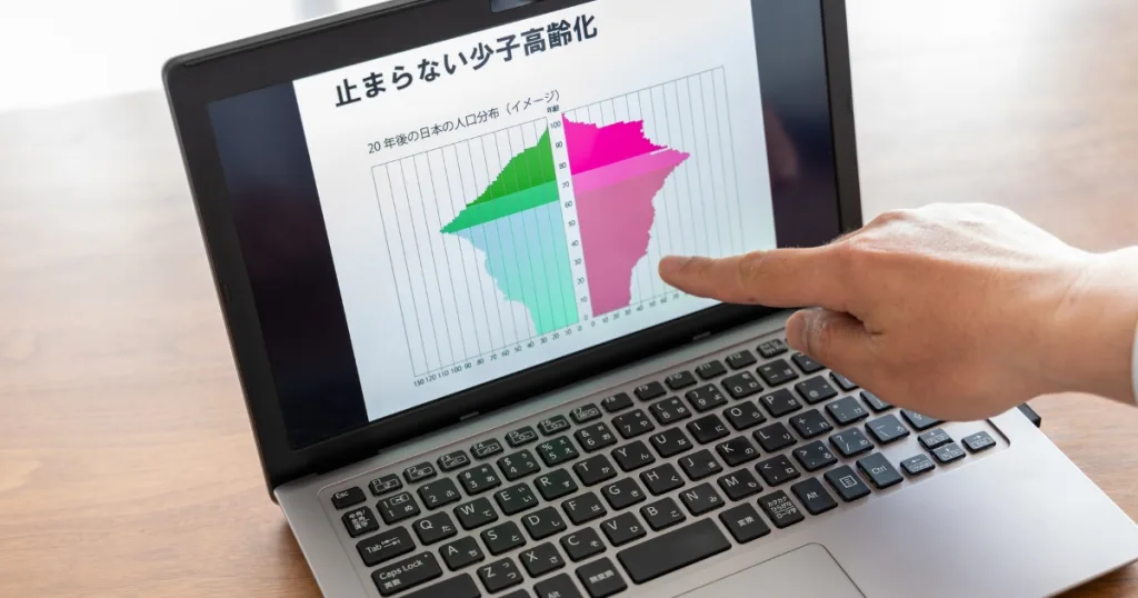 パソコンの画面に止まらない少子高齢化のグラフが表示されている