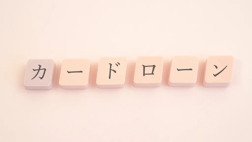四角いブロックにカードローンの文字、薄いオレンジ色の背景