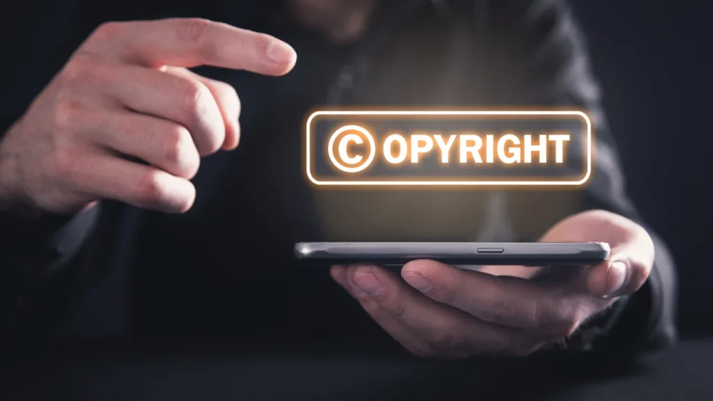 スマホを持つ手とCOPYRIGHTの文字