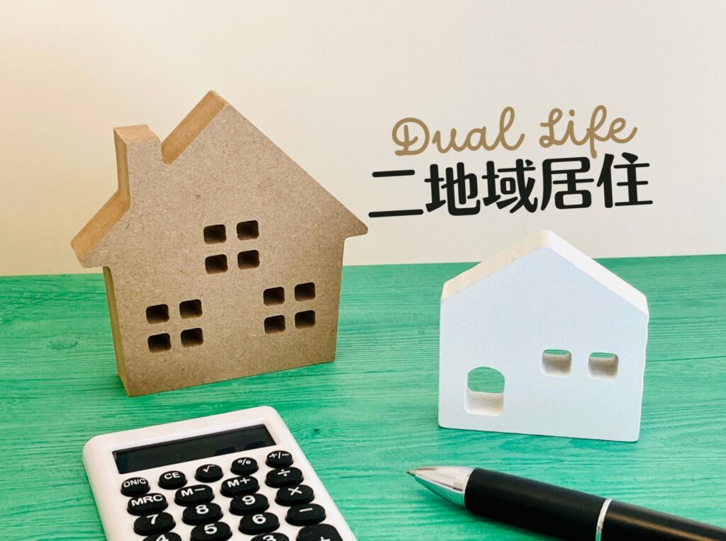 模型の家が2つと電卓と二地域居住の文字