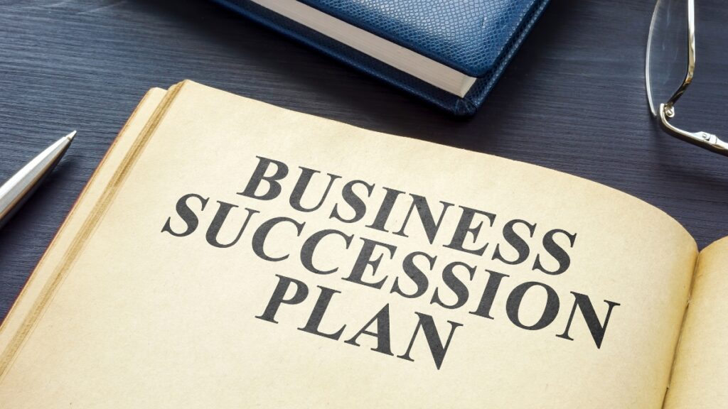見開きの本にBUSINESS SUCCESSION PLANの文字