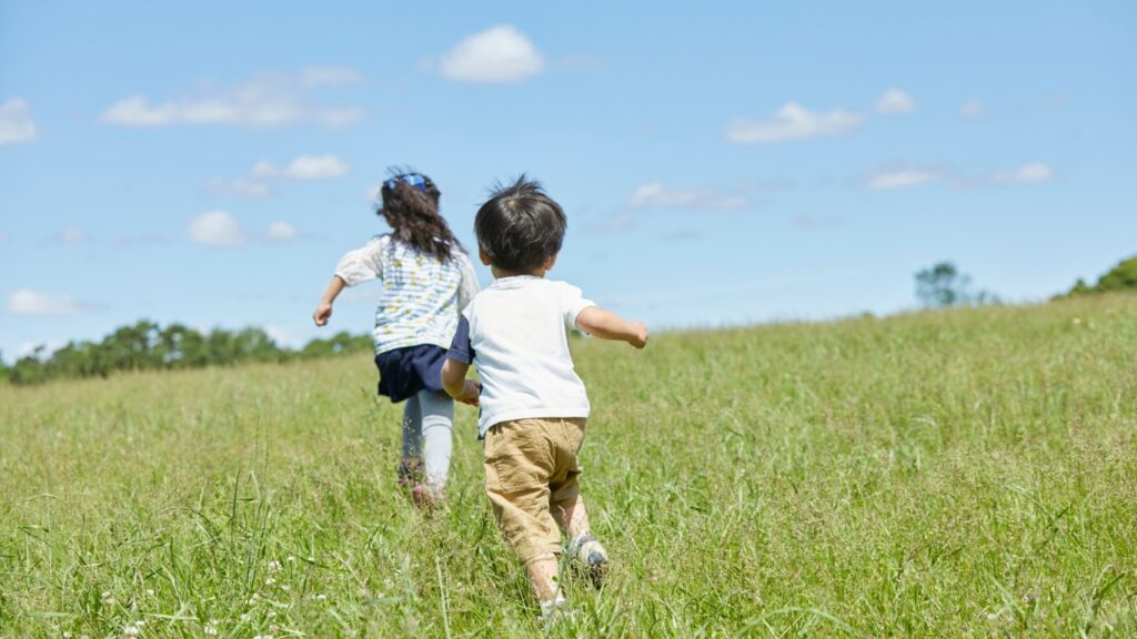 子どもが野原を駆け回る