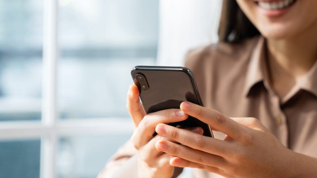 笑顔でスマホを操作する女性