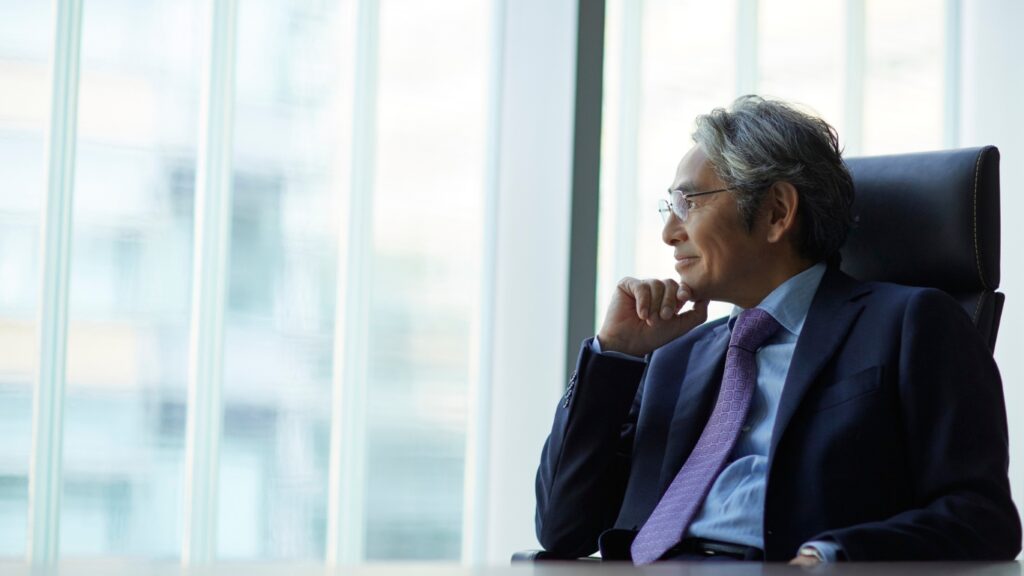 経営者が窓の外を見ている