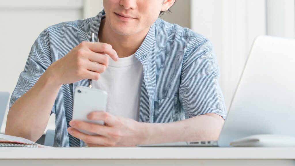 スマホを操作する男性大学生