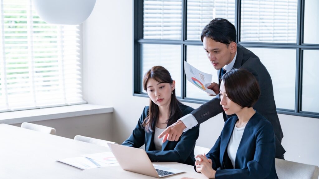 パソコンを前に議論する会社員たち