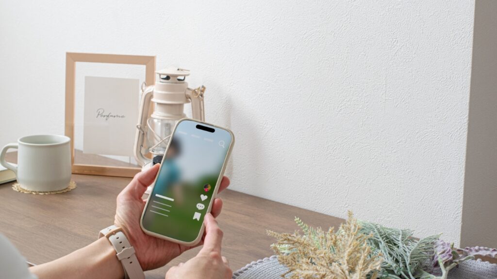 ライブ配信をスマホで視聴する女性の手