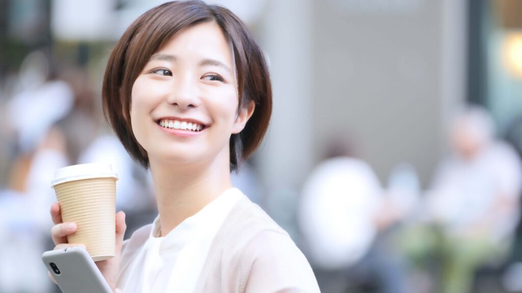 スマホとコーヒーを20代女性