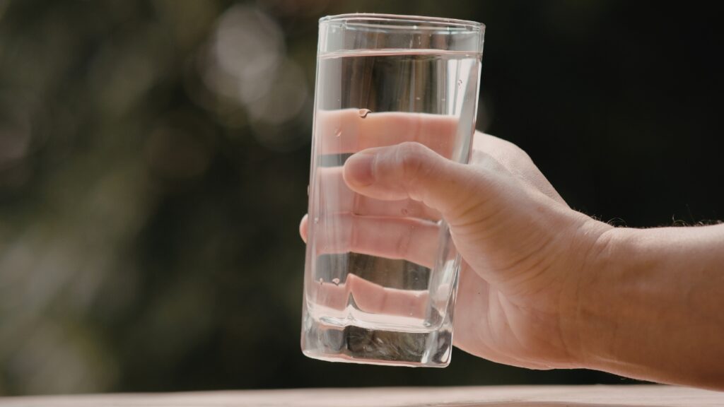 グラスに入った水を持つ手