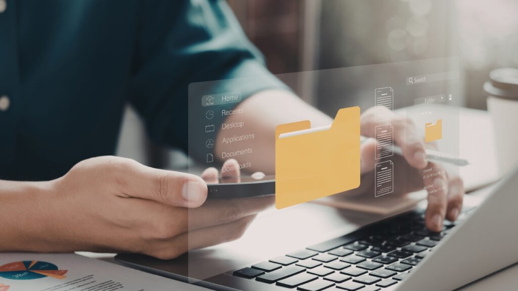 ノートパソコンでデジタルファイルフォルダを使用している人物 