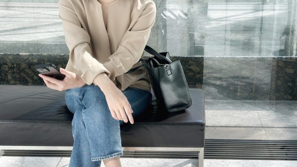 スマホを手に待つ女性