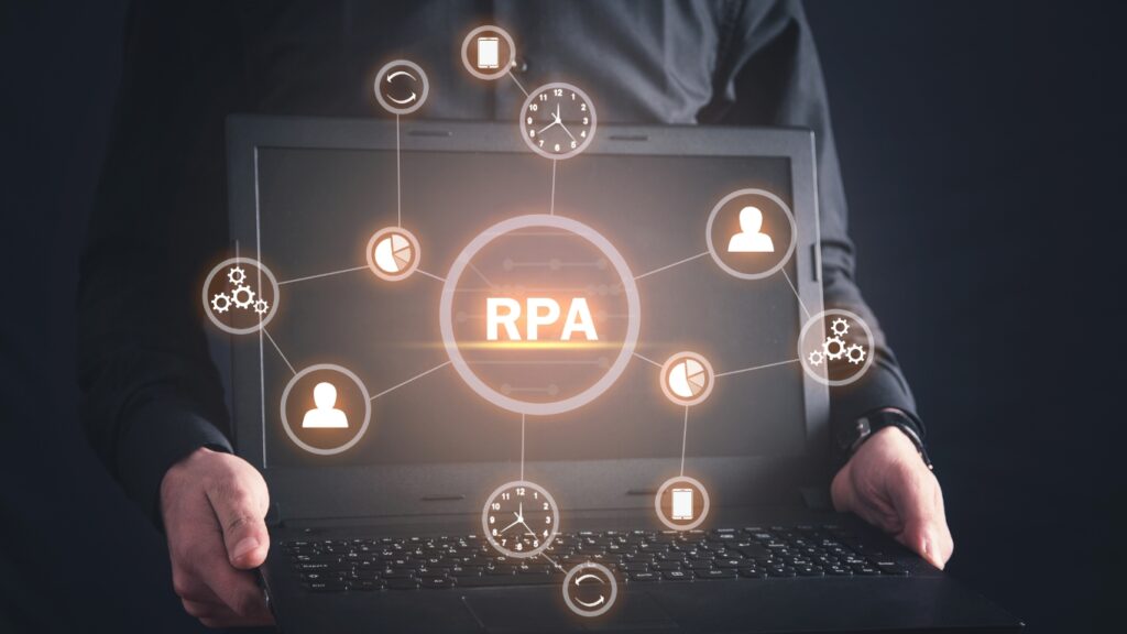 ノートパソコンを持つビジネスパーソンとRPAの文字